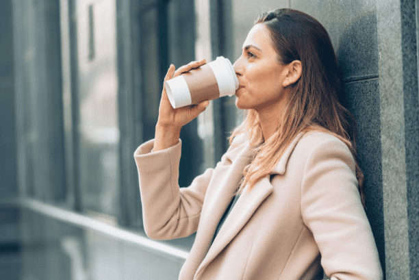 OPT Blog Image - Employee enjoying a warm dunkin or starbucks beverage outside the office