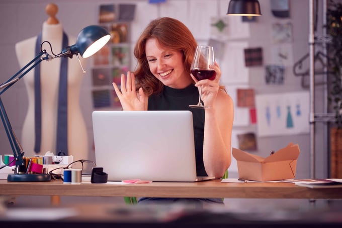 Woman participating in remote happy hour for team celebration.