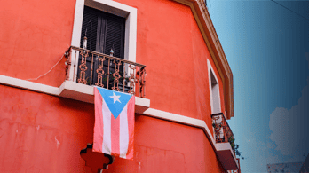 Puerto Rican flag flying out of the window of a red building