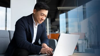 businessman using his laptop to manage his gift card incentive program