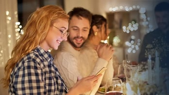 employee at thanksgiving dinner receiving a gift on her phone