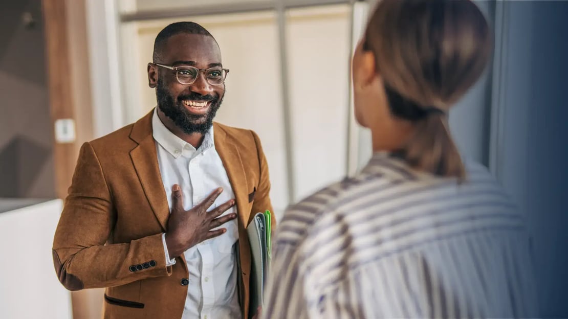 employee recognition mistakes featured image smiling business man receiving recognition from female colleague