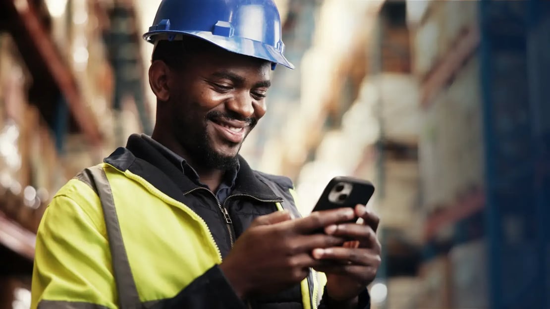 happy frontline worker receiving a digital reward on their phone and looking at their phone