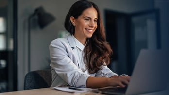 happy female HR worker happy at her laptop at home