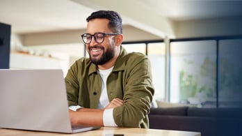 happy real estate working from home on his laptop  