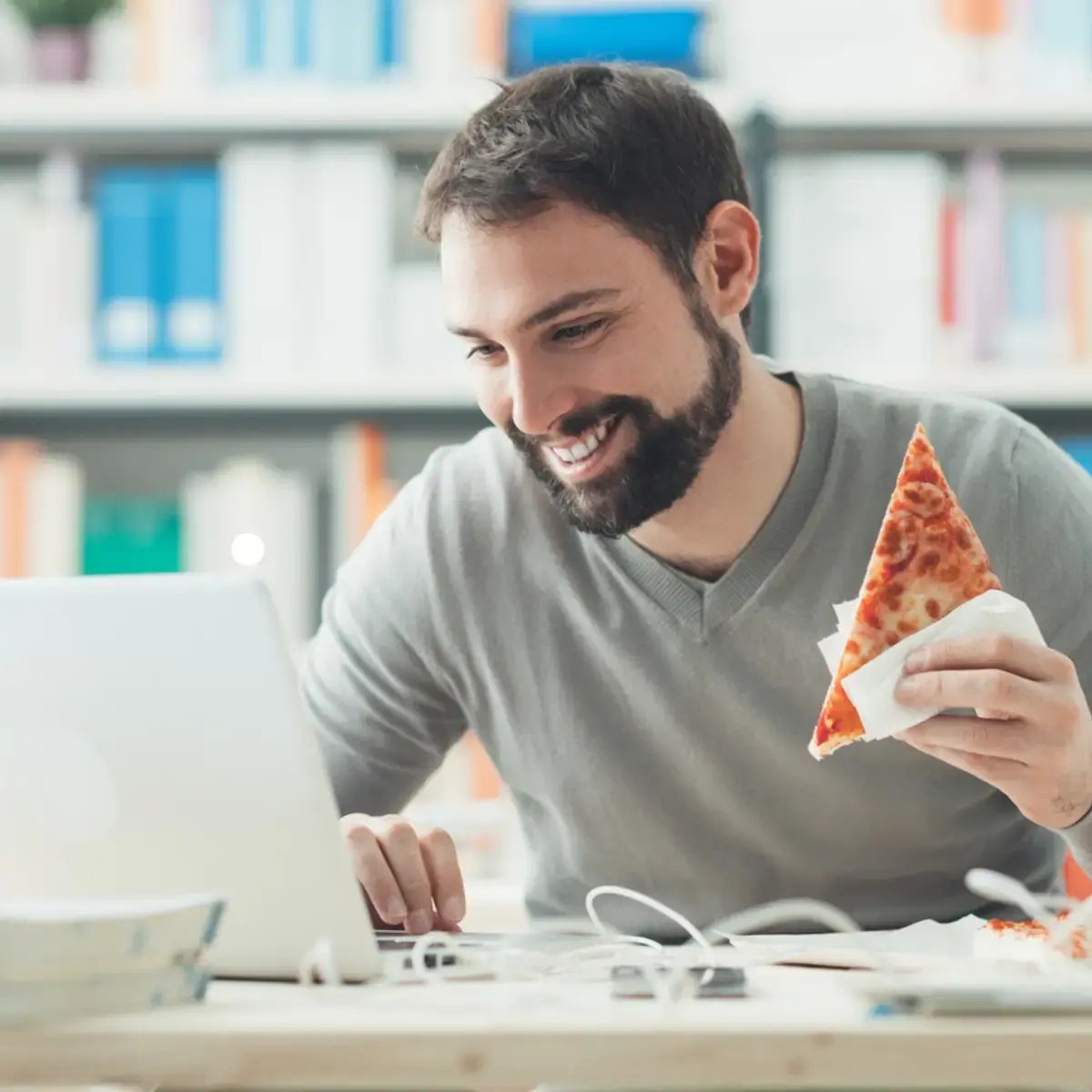 remote employee eating pizza at desk