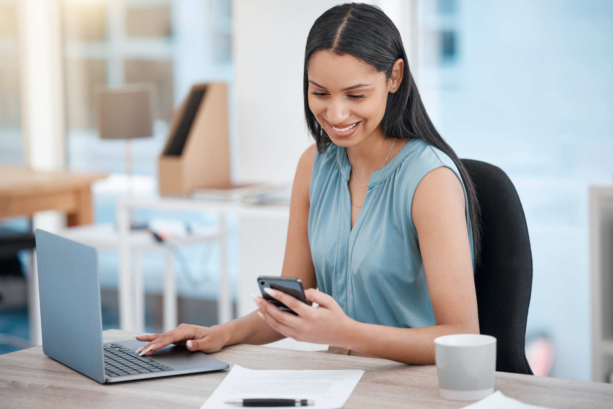 business woman smiling and looking at phone while getting a digital corporate gift